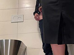 Eine MILF mit großem Hintern gibt einen Handjob und lässt dich in einer öffentlichen Toilette kommen