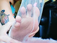 Egy rabul ejtő tetovált nő lábának imádása