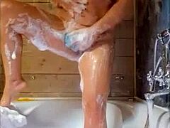 Ibu rumah tangga dewasa memuaskan dirinya sendiri di bak mandi dengan jari-jarinya