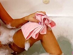 En moden brunette collegestudent viser frem sin vakre kropp under et avslappende bad