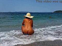 Rijpe vrouw met uitgerekte tepelpiercings en meerdere kutjes piercings op het strand