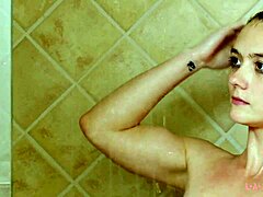 Attraktiv brunettmodell badar i en het dusch
