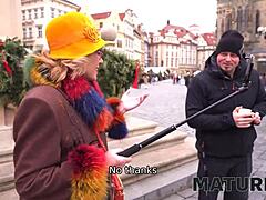 Vanha nainen nauttii koiranpentuista nuoren miehen kanssa Prahassa