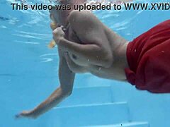 MILF berambut perang dengan payudara semula jadi mempamerkan badannya di kolam renang