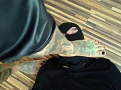 En tatovert MILF dominerer sin fotslave i en varm barfodet video
