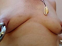 Kinky MILF met pierced tepels wordt kinky tijdens een BDSM-sessie in de buitenlucht